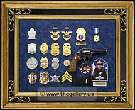 Police retirement shadow box with gun, badges, patchs, photo, lapel pins and awards.
kennesaw_georgia_frame_shop.jpg